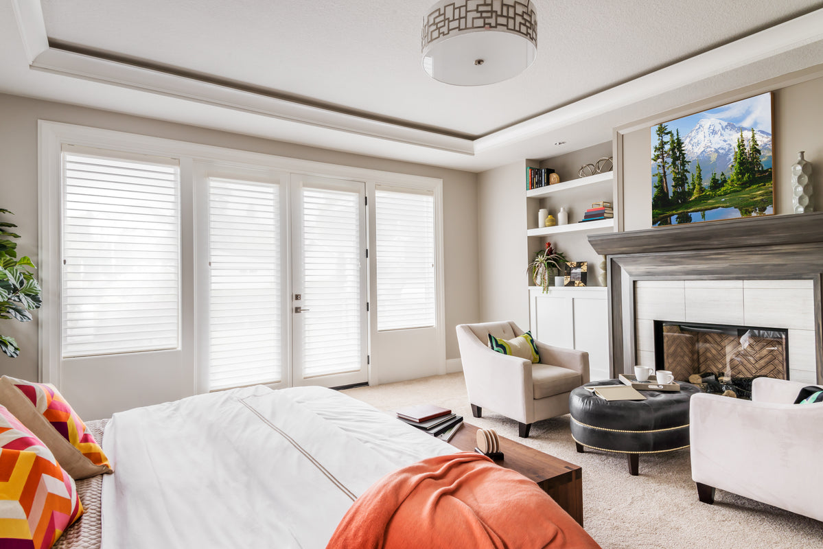 a bedroom with a queen sized bed and large windows